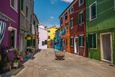 Street amidst houses against buildings in city