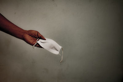 Close-up of hand against white wall