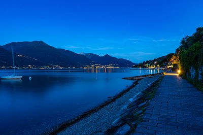 The town of pianello del lario, on lake como, and the promenade along the lake, at dusk. 