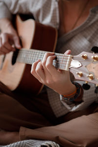 Midsection of man playing guitar