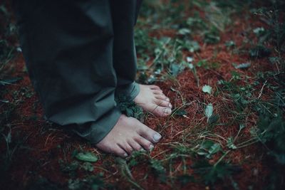 Low section of man standing on field