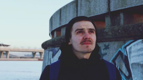 Man looking up against built structure