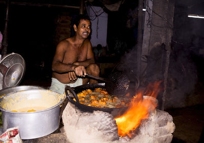 Shirtless man preparing food