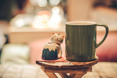 Close-up of cat toy and coffee cup on table at cafe