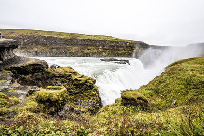 Scenic view of waterfall against sky