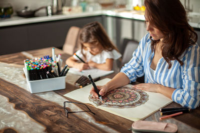 Woman and girl sitting on table