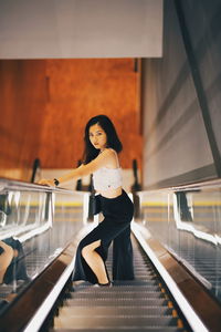 Woman standing on escalator
