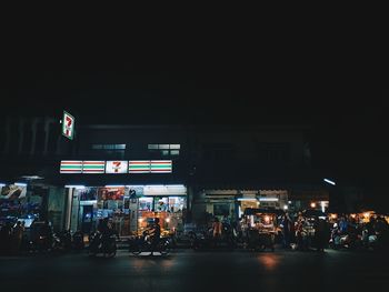 People at illuminated city street at night