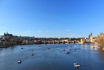 Boats in river against buildings in city