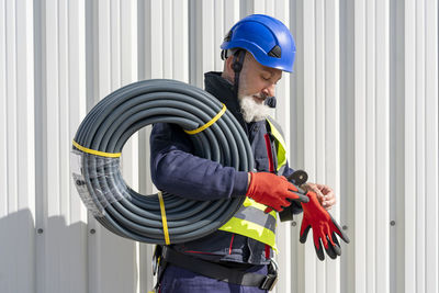 Engineer with cables wearing protective glove on sunny day