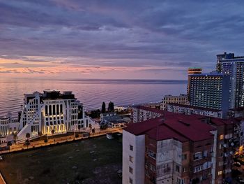 High angle view of city by sea against sky