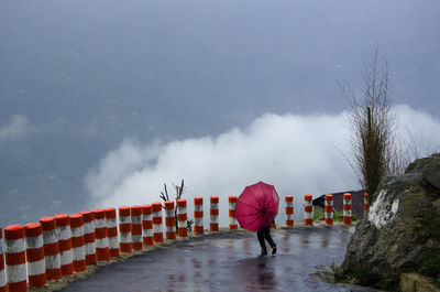 Rear view of people walking on road during rainy season