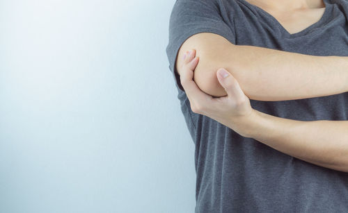 Midsection of woman standing against wall