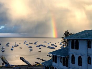 Scenic view of rainbow over sea against sky