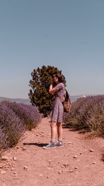 Woman standing on field against clear sky