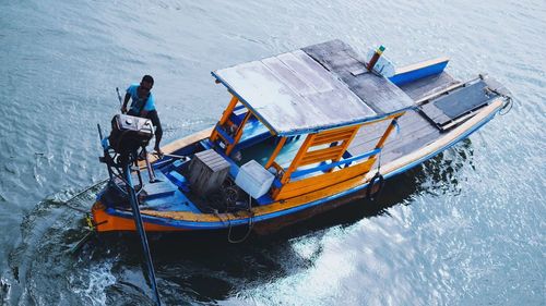 High angle view of man standing on boat in sea