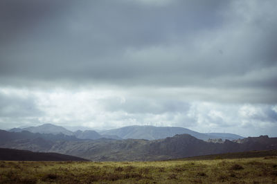 Scenic view of land and mountains against sky
