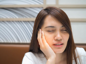 Woman suffering from toothache at home