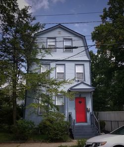 House by trees against sky in city