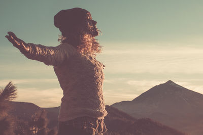 Silhouette woman standing on mountain against sky during sunset