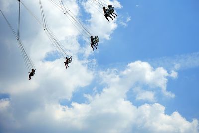 Low angle view of people on chain swing ride