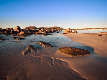 Scenic view of beach against clear blue sky