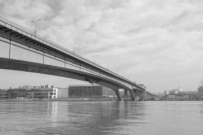 Bridge over river against sky in city