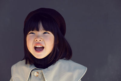 Korean girl in a gray coat and cap and stands the street in spring.