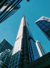 Low angle view of 432 park avenue against blue sky