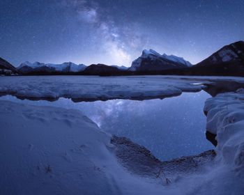 Scenic view of snowcapped mountains against sky at night