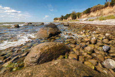 Surface level of rocks on shore against sky