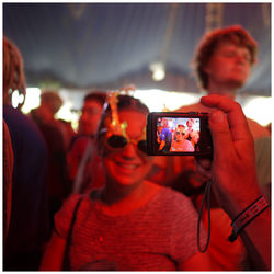 Midsection of woman photographing with mobile phone at night
