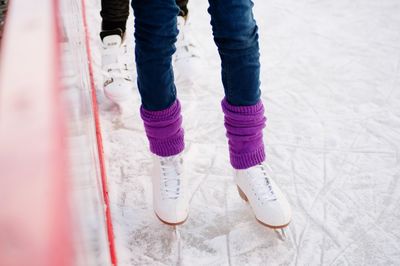 Low section of people ice-skating on rink