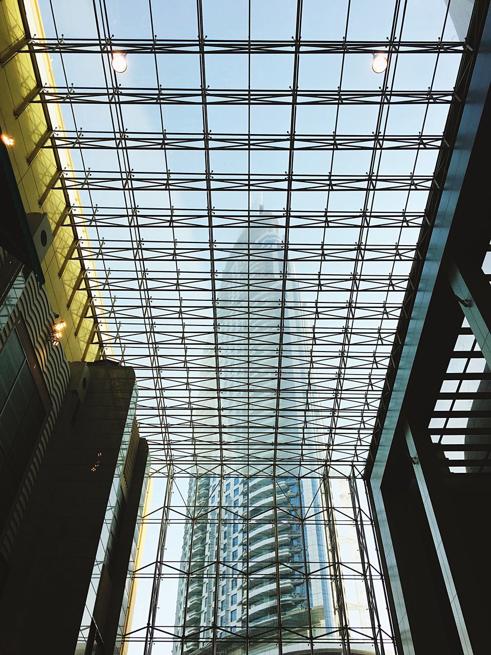 low angle view, indoors, ceiling, architecture, built structure, directly below, sky, skyscraper, tall, day, repetition, modern, skylight, geometric shape, tall - high, diminishing perspective, architectural feature, conformity, no people, architectural design