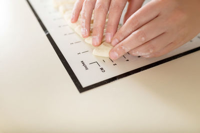 Cropped hands of woman using laptop on table