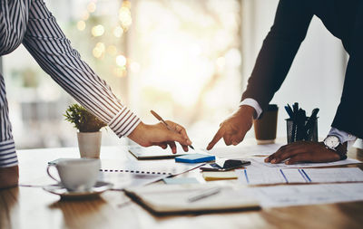 Midsection of business colleagues working on table