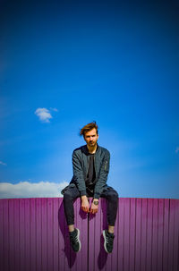 Man standing against blue sky