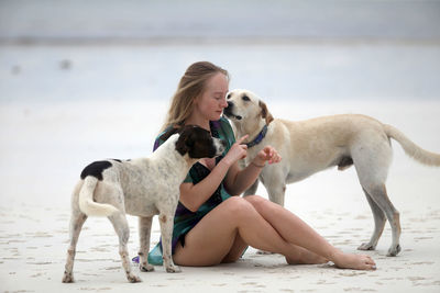 Full length of young woman with dog on beach