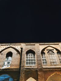 Low angle view of old building against clear sky at night