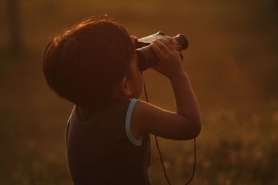 Rear view of boy playing on land