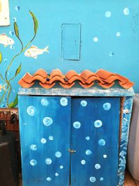 Close-up of blue metal on table against wall