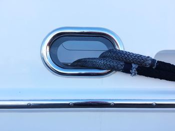 Close-up of metal tied on boat against sky