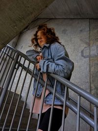 Portrait of woman sitting on railing