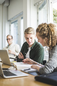 Male and female students studying in classroom at university