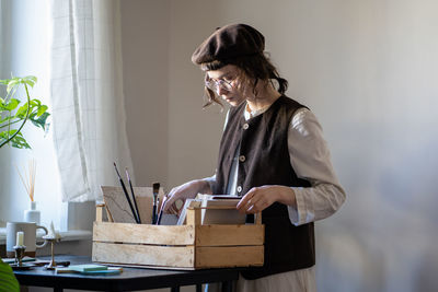 Side view of woman using digital tablet while sitting on table