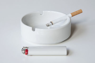 Close-up of cigarette over white background
