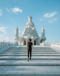 Full length rear view of senior woman against building