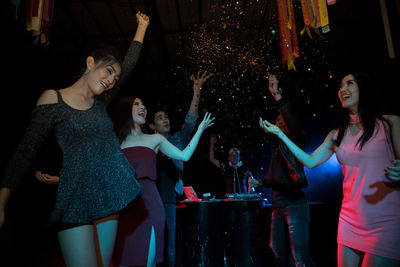 Happy people dancing in nightclub