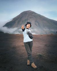 Portrait of young man standing on mountain