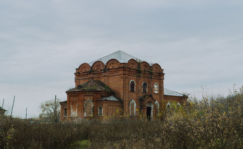 Low angle view of old building on field against sky